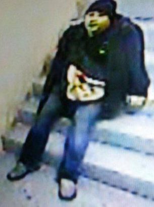  The man sits on a set of stairs in one of two stills released by police in Manila