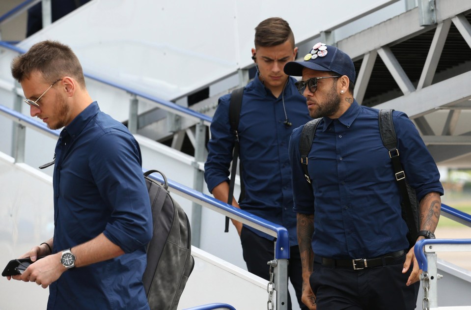 Dani Alves and Paulo Dybala look in focused frames of mind as they walk off the plane in South Wales