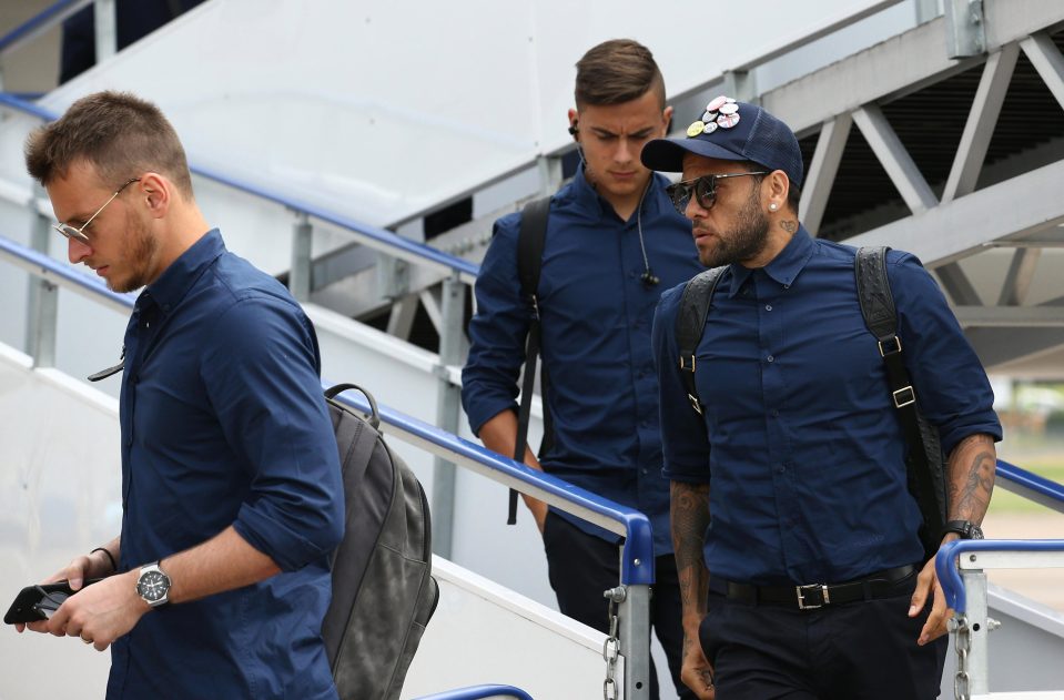  Dani Alves and Paulo Dybala look in focused frames of mind as they walk off the plane in South Wales