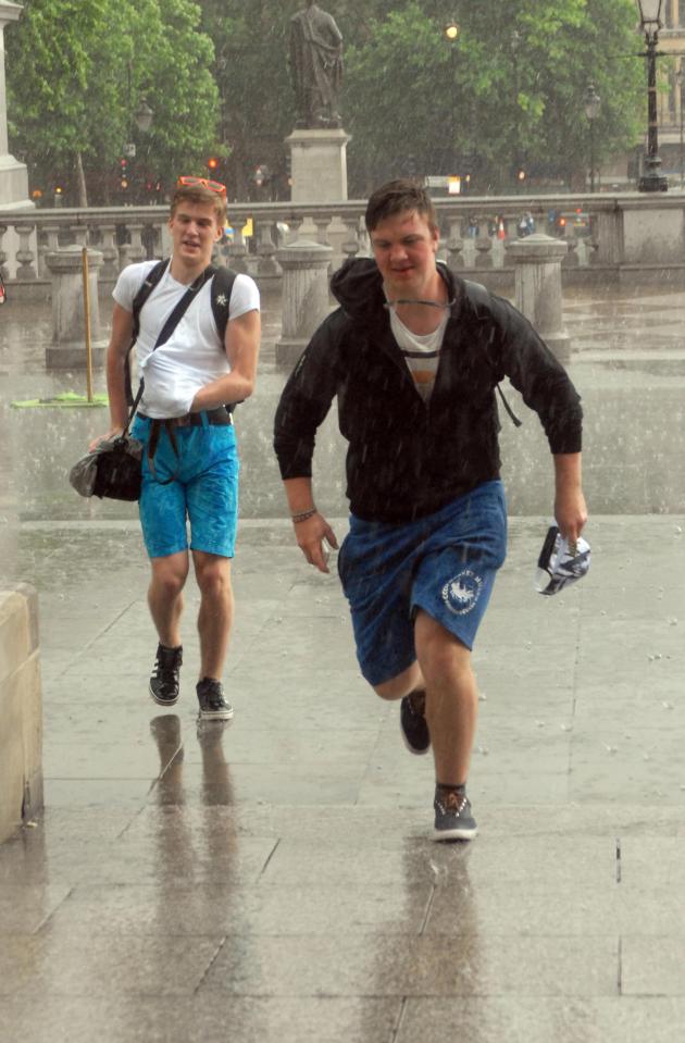  Two men make a dash for cover this afternoon in Trafalgar Square