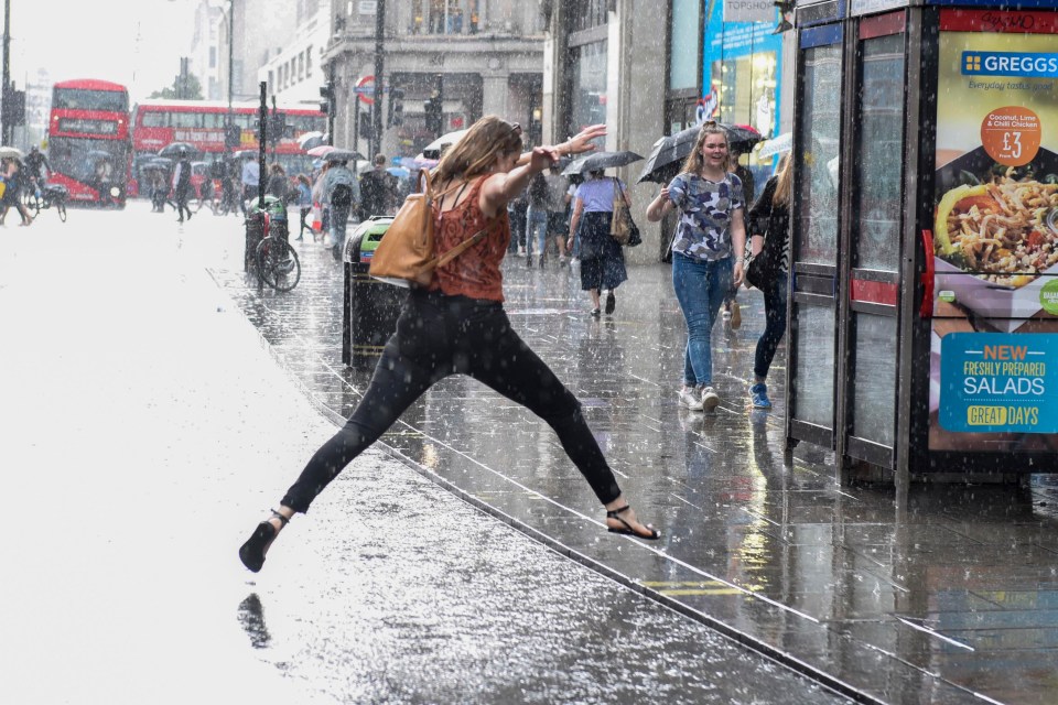 Commuters, shoppers and tourists react to a sudden thunderstorm which brings a heavy downpour to Oxford Street