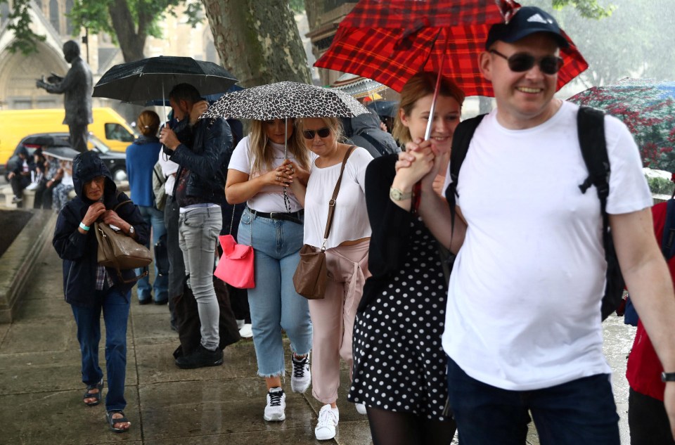 Caught in the thick of it … Londoners brave the wet weather on Friday afternoon