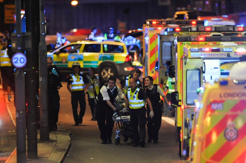 Police officers and members of the emergency services tend to a person injured in the terror attack on London Bridge in 2017