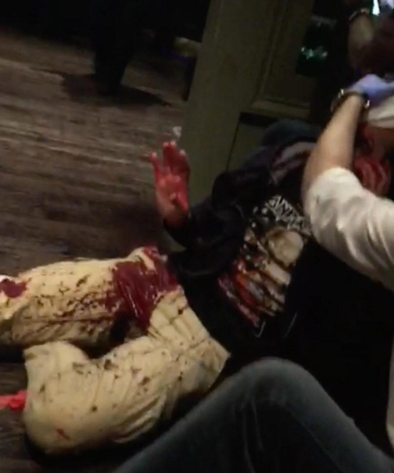 A victim of the attack lays on the floor of the pub, with chaos around him