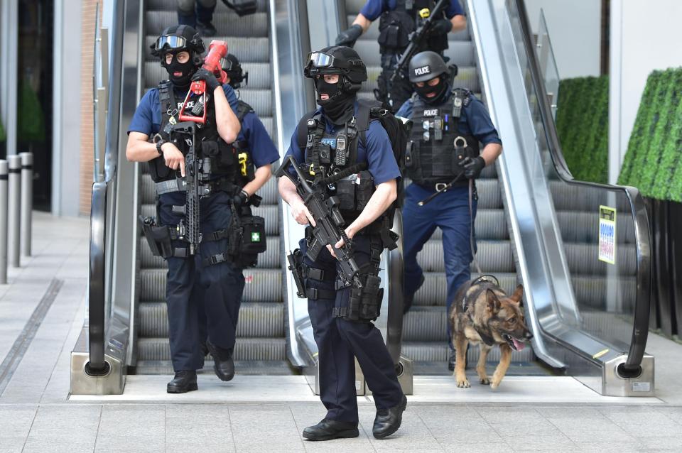  Armed police make their way down escalators next to the iconic Shard