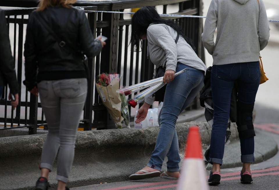 People leave flowers in London Bridge today as cops comb the area for evidence