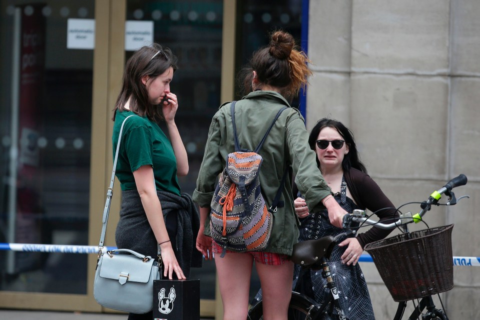 A girl wipes away a tear as she visits the scene of last night's atrocity 