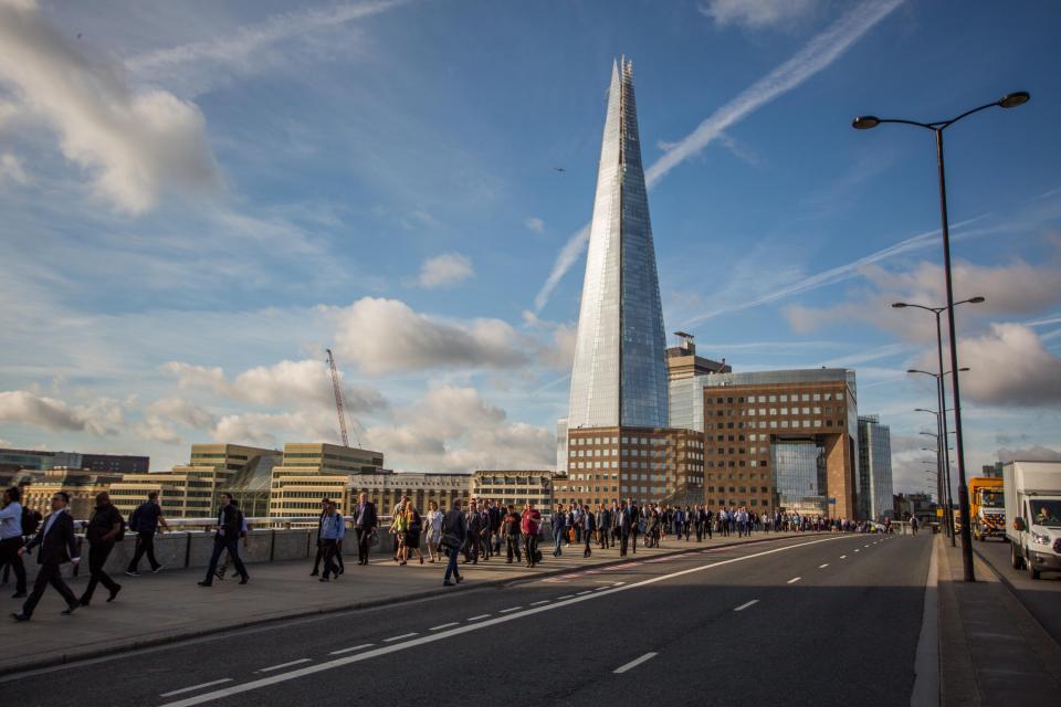  Defiant Londoners cross London Bridge on their way to work after the terror attack on Saturday night