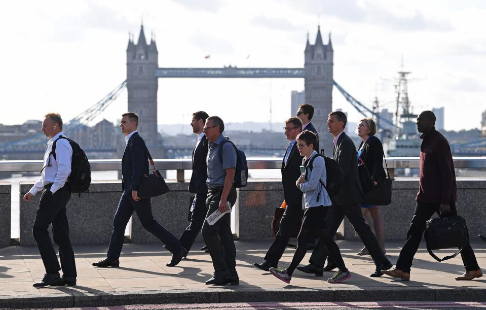  People cross London Bridge as Tower Bridge can be seen in the background