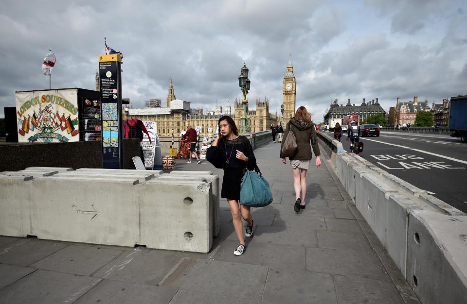  A young woman makes her way past the concrete blocks, which are now visible on three bridges in London including Westminster