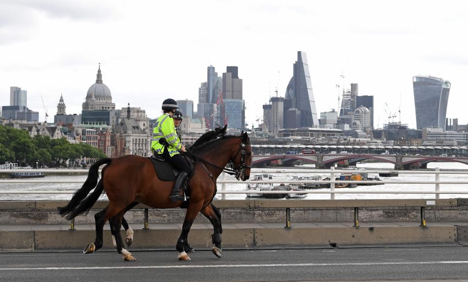  Mounted police ride past a security barrier on Waterloo Bridge today