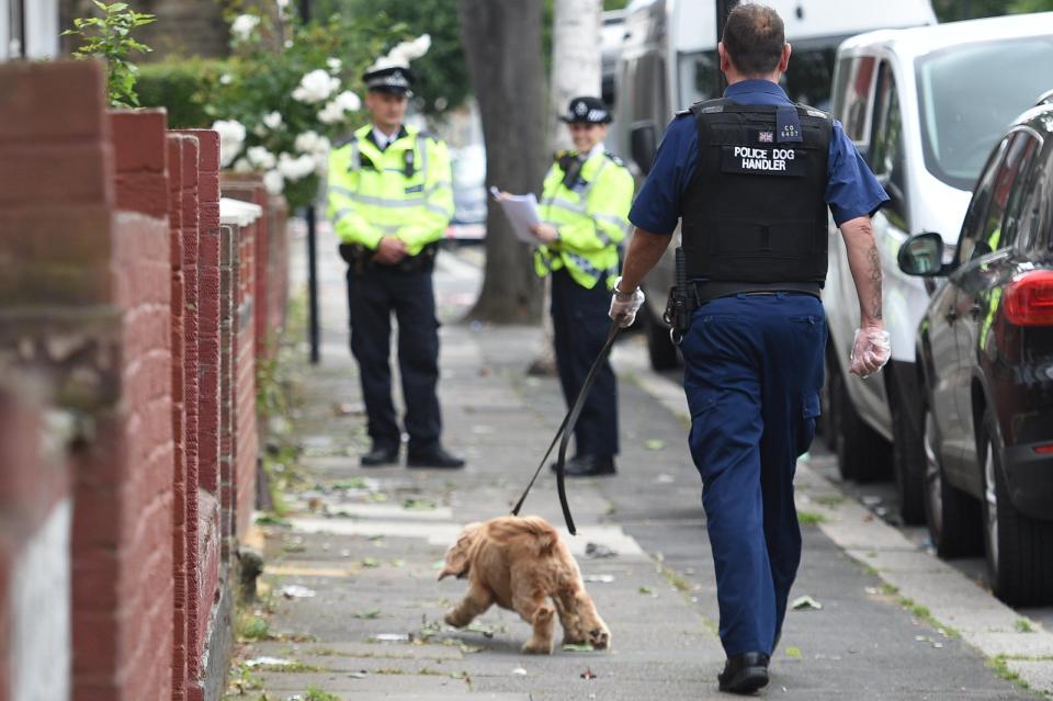  A sniffer dog is brought to a house in East Ham raided by cops