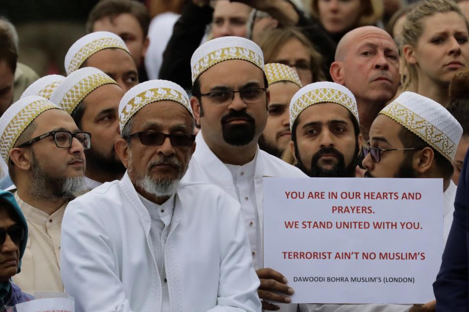  Others pay their respects at the vigil with defiant messages