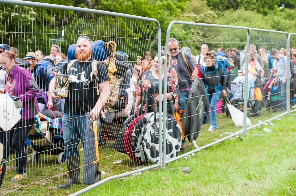  Festival-goers queue at the gates into the park with their belongings and tents ahead of the weekend