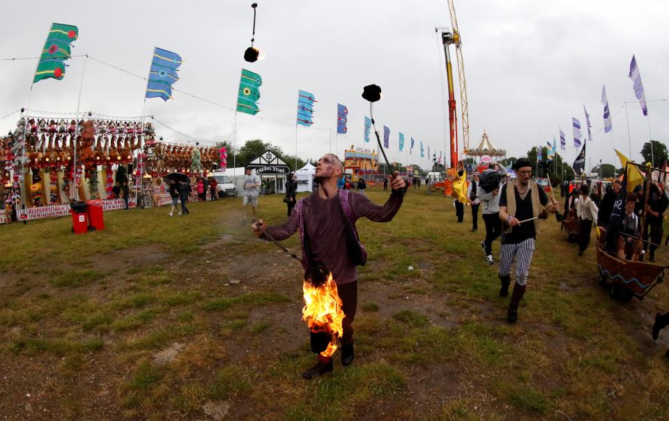  A man appears to juggle three flaming batons as he parades through the annual festival