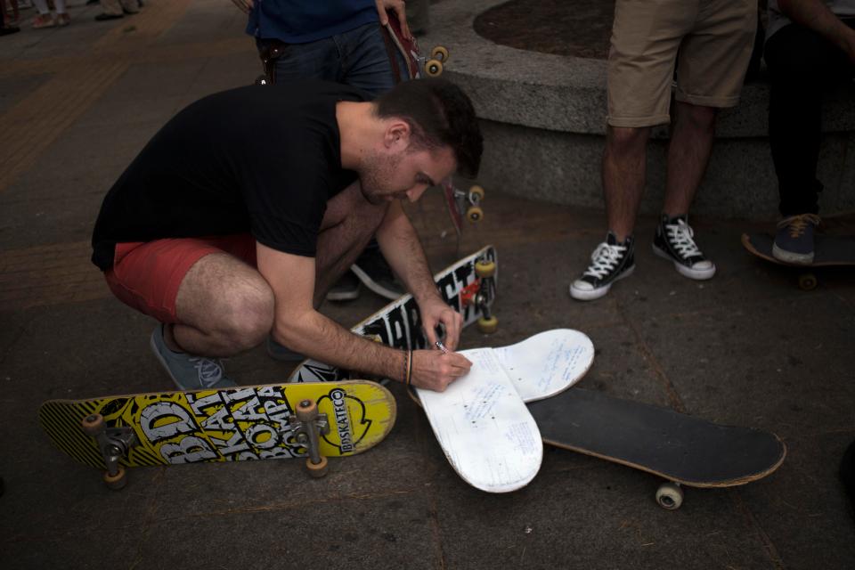  Friends wrote messages of condolence on a broken skateboard during a vigil in his memory