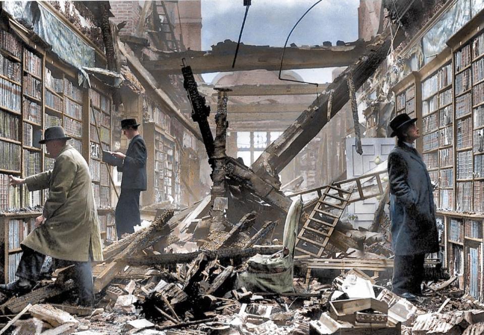  1940: Readers take a look at the books at the bomb-struck library of Holland House, London. Today, only the east wing and ruins of the historic building's ground floor still remain.