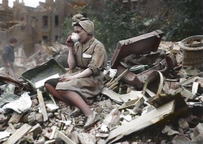  1940: A woman sips a cup of tea after her street is struck by a German bombing raid. The Blitz killed around 43,000 civilians during the war