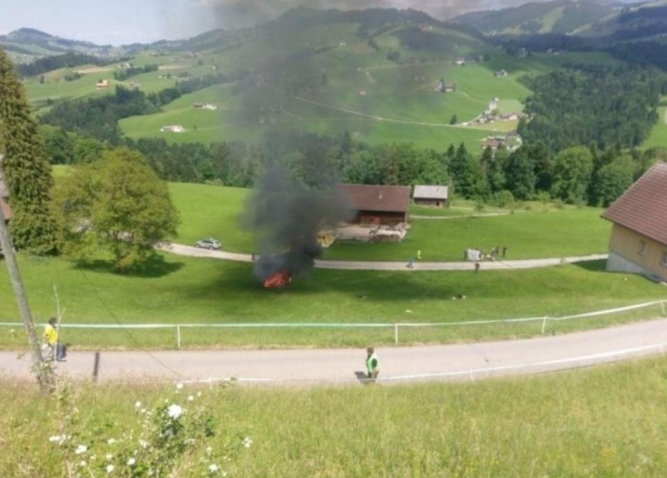  The car in flames after rolling down a hill