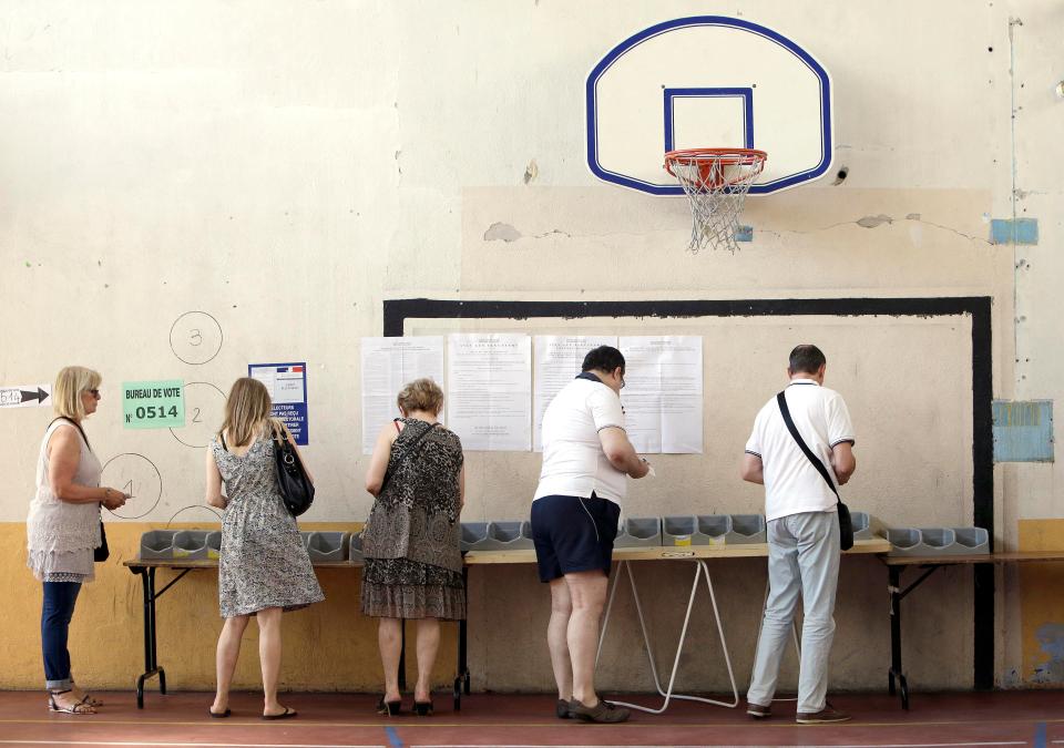  Voters pick up ballots at a polling station before voting for the first round of parliamentary elections in Marseille