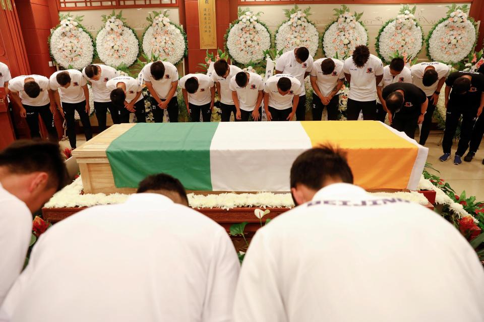  Beijing Enterprises players bow their heads in tribute to former team-mate Cheick Tiote