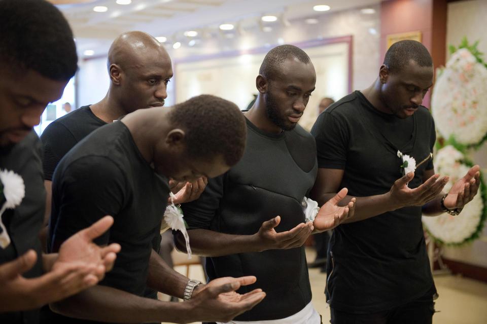  Cisse and Tiote's close friends pray in front of his coffin