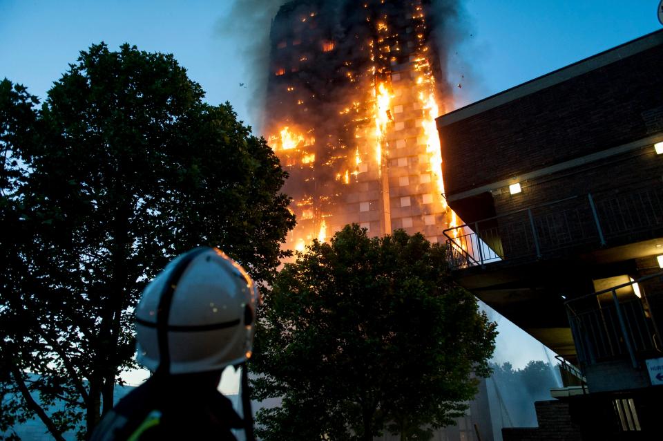  A firefighter looks on at the tower blaze during the early hours of the morning