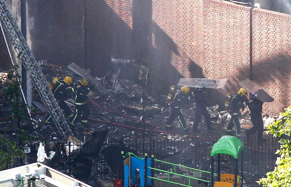  Fire crews sift through the debris following the fire overnight