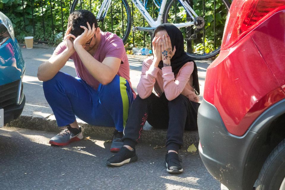  Two residents hold their heads in the hands as they struggle to comprehend the carnage