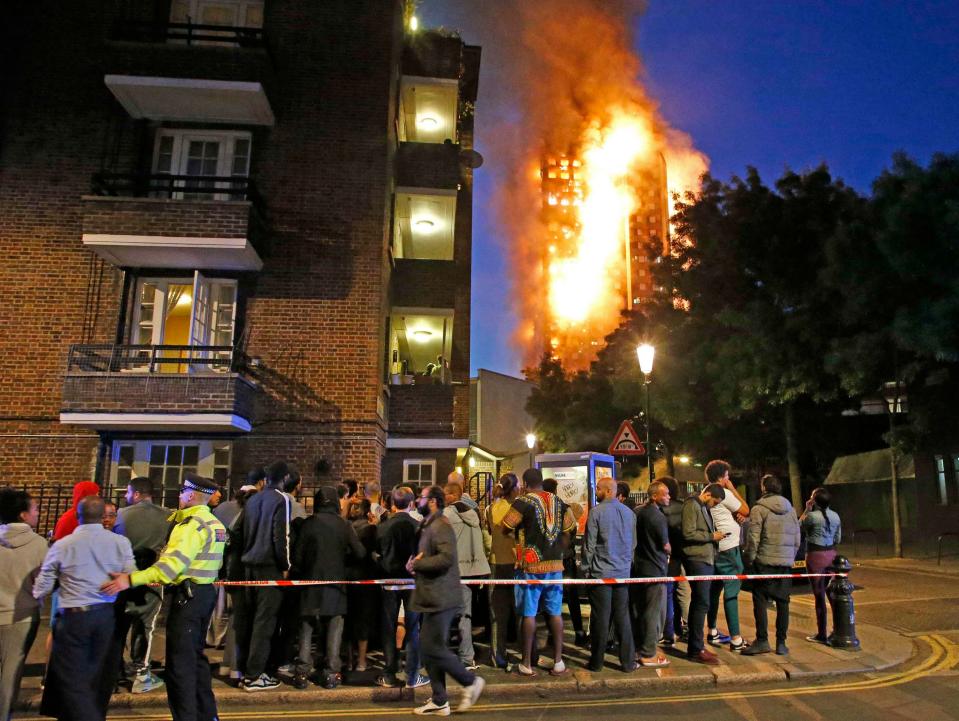  Residents evacuated from the building as the fire rages on in the background