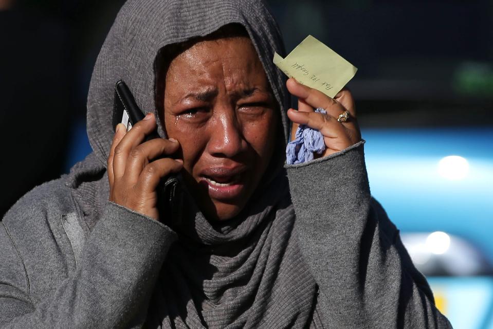  Woman cries as she desperately hunts for missing relative who hasn't been seen since the blaze