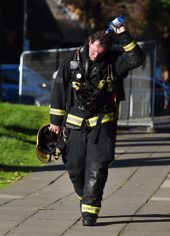  A firefighters pours water over his head after battling the enormous blaze