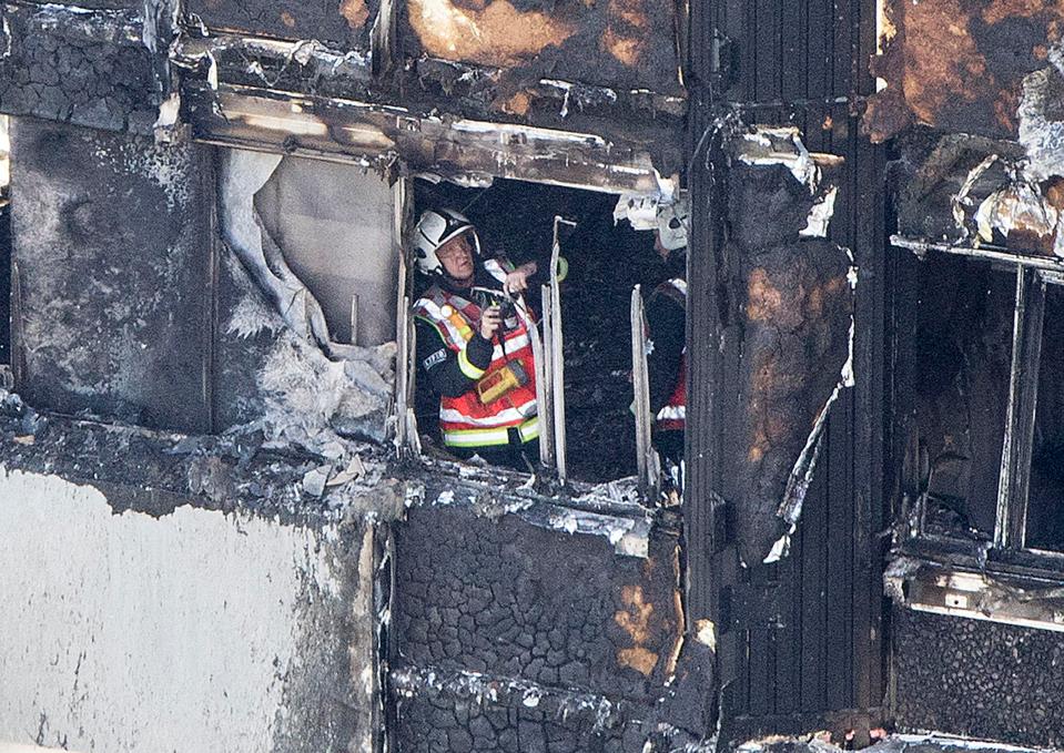  A fireman surveys the burnt out high rise block of flats