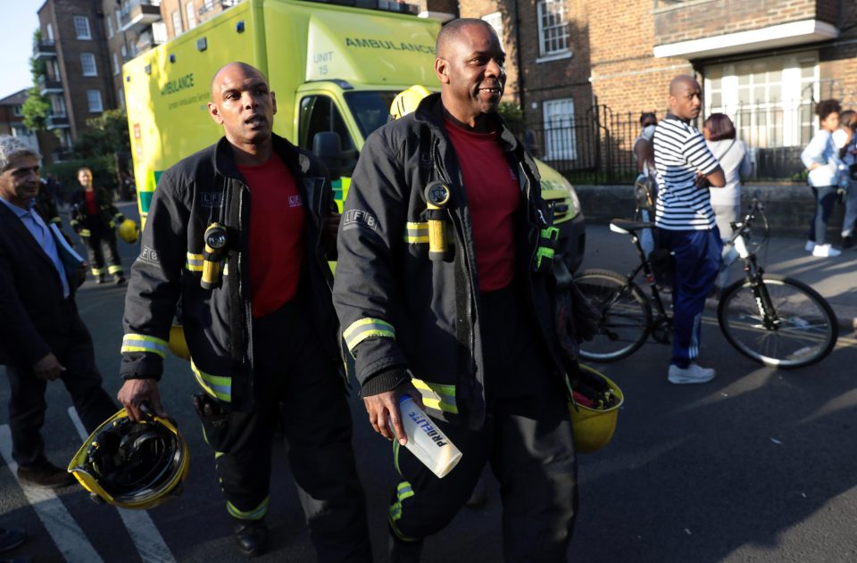  Two firefighters near the scene of the fire which ravaged the social housing block