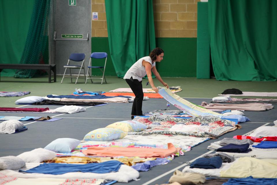  A woman lays bedding to Westway Sports and Fitness Centre for the survivors of the Grenfell Tower blaze