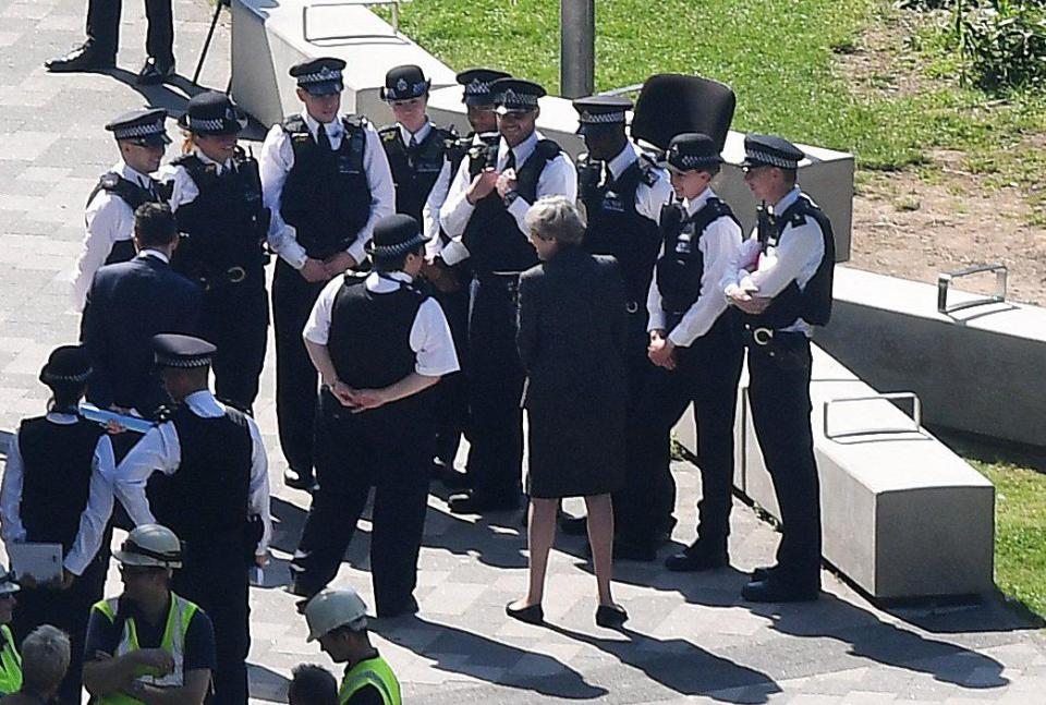  Prime Minister Theresa May speaks with police as she visits Grenfell Tower today