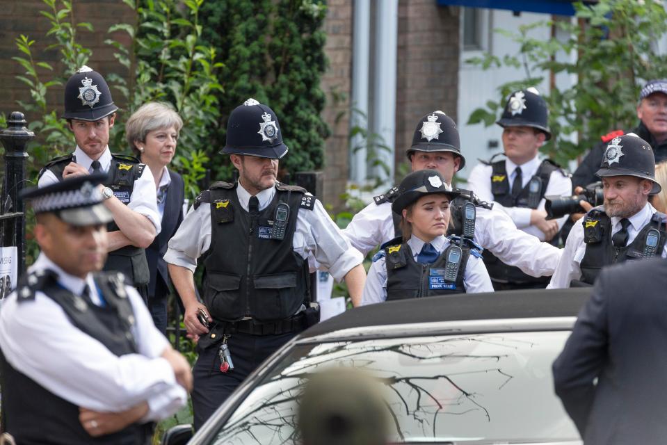  Theresa May was surrounded by police as she left St Clement's Church - close to Grenfell Tower yesterday