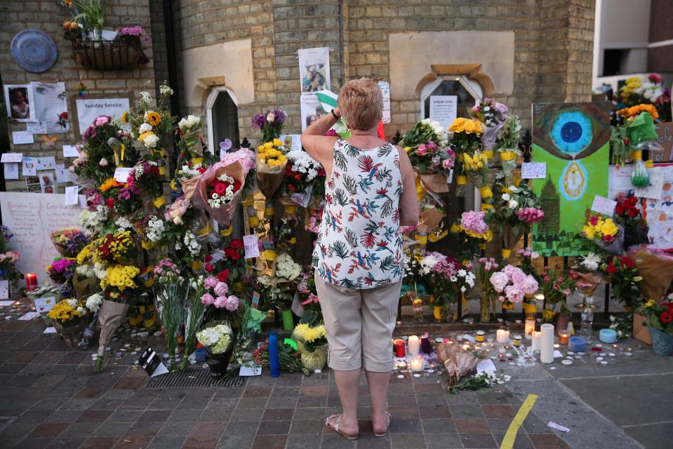  A woman stops by the wall of tributes erected in Notting Hill for those who perished in the fire