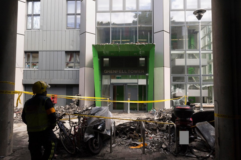 A shocked firefighter takes in the scene of carnage outside the West London block of flats