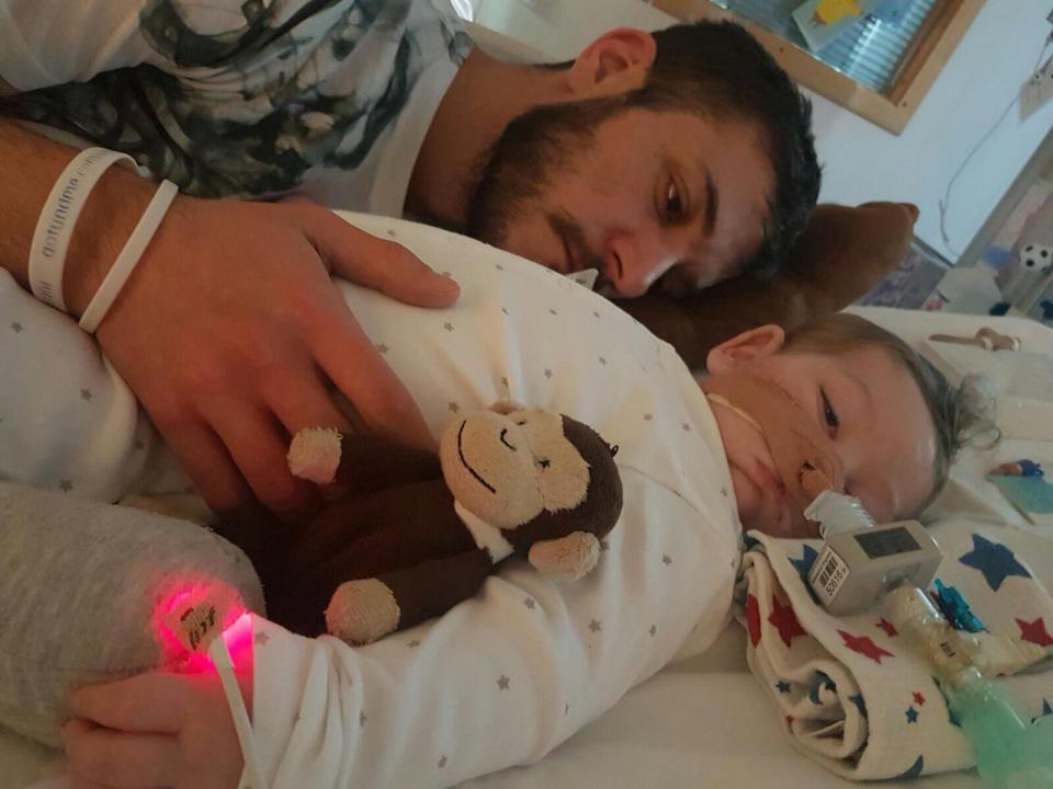  Chris Gard cuddling his son Charlie in his hospital bed