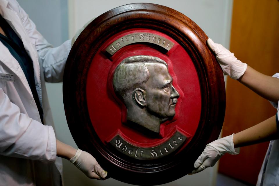  Members of the federal police show a bust relief portrait of Nazi leader Adolf Hitler at the Interpol headquarters in Buenos Aires