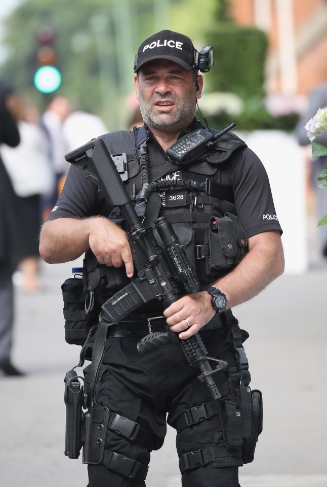 This armed officer carries a rifle and has a handgun strapped to his leg