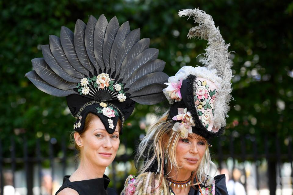  One woman turned heads in an enormous black fan design, while her mate went for a towering headpiece that was adorned with grey feathers and blush pink blooms