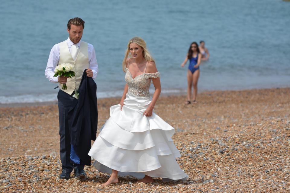  A pair of models wear wedding gear for a photoshoot on Brighton beach, where most other people were dressed more appropriately for the weather