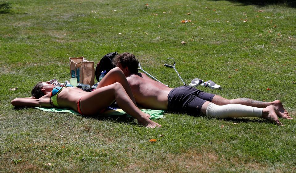  A couple sunbathing in scorching Green park in central London today