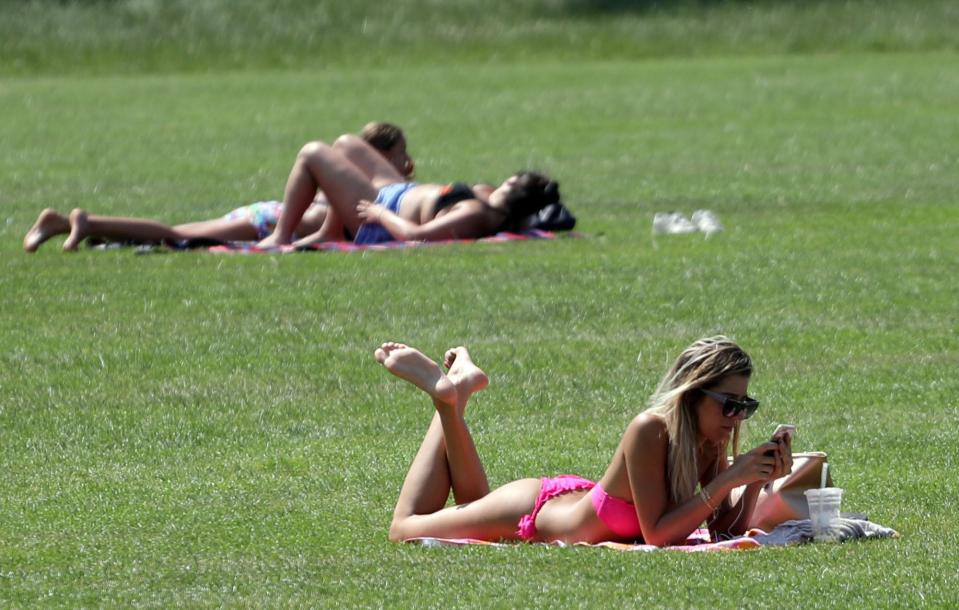  Sunbathers soak up the rays today on Hampstead Heath, London