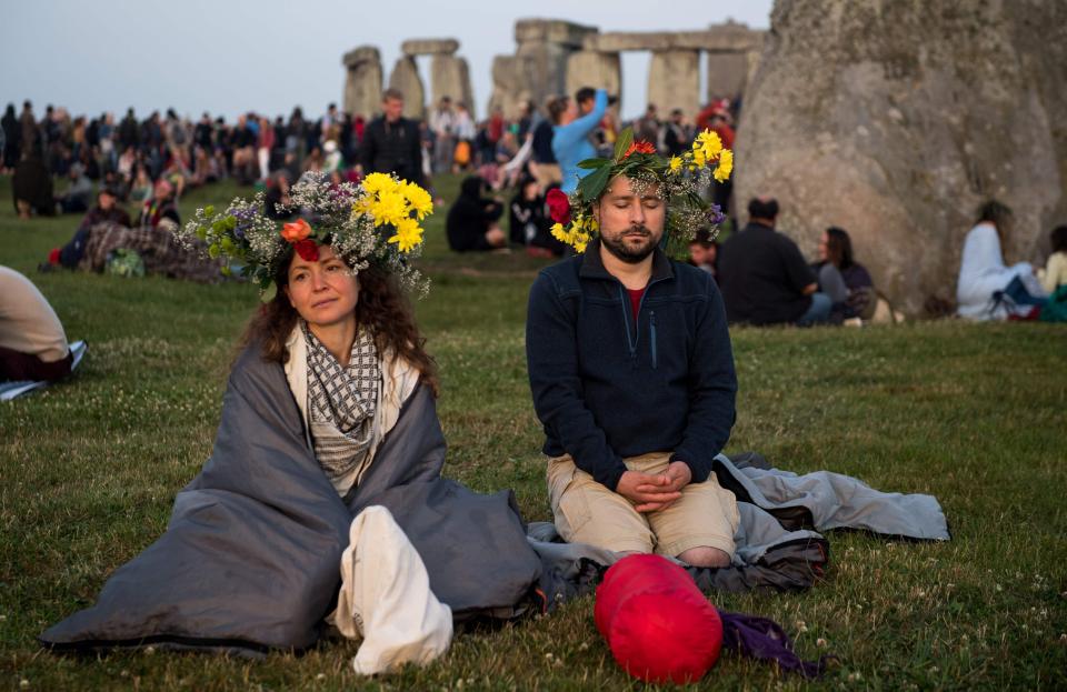  Two people watch the sunrise at Stonehenge during the Litha festival