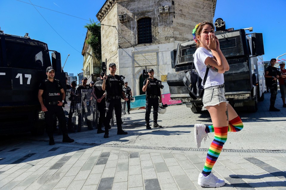 A gay rights campaigner mocks officers blocking the Istanbul parade