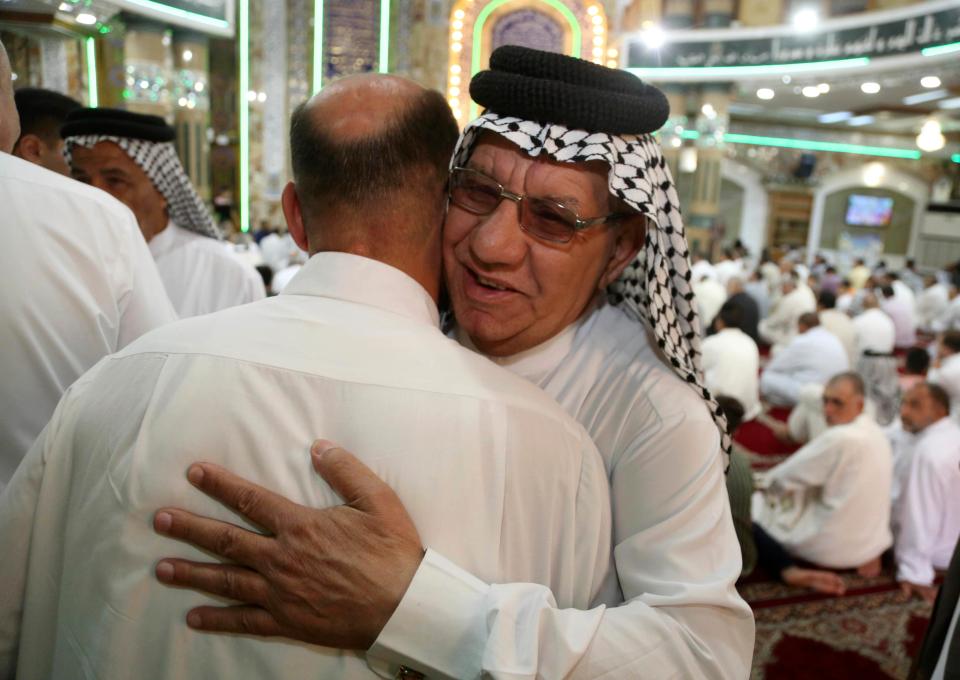  Two men hug in Baghdad, Iraq, on the first day of Eid al-Fitr