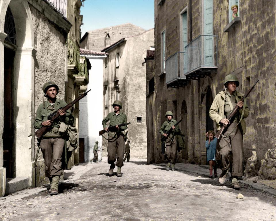  A young girl takes a peep at American GIs in the streets of Caiazzo, Italy - just north of the River Volturno. The River Volturno in Campania was a line of defense for the Germans as they retreated following the Allied capture of Naples.